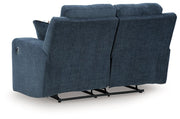 Ashley Furniture Danum reclining loveseat with plush fabric upholstery and padded armrests, shown from the back.