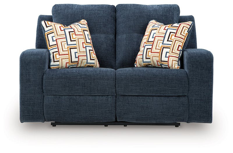 Ashley Furniture Danum reclining loveseat with plush fabric and cushioned armrests, shown in a head-on view.