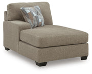 Ashley Furniture Newellen sleeper sectional with chaise, featuring plush cushions and a modern design in a spacious living room setting.