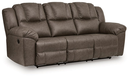 Ashley Furniture Lowilla reclining sofa shown from an angle, with plush fabric and padded armrests in a cozy living room setting.