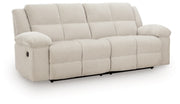 Ashley Furniture Orlen reclining sofa in a neutral fabric, shown from an angled view highlighting the plush cushions and recliner mechanism.