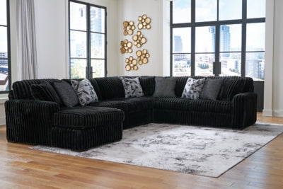 Ashley Furniture Midnight-Madness sectional with chaise, featuring plush cushions and modern design in a cozy living room setting.
