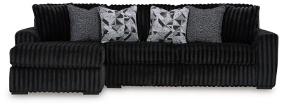 Ashley Furniture Midnight-Madness sectional sofa with chaise, featuring plush cushions and modern design in a cozy living room setting.