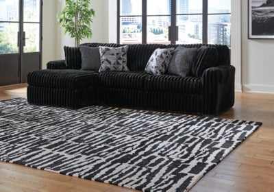 Ashley Furniture Midnight-Madness sectional sofa with chaise, showcasing plush upholstery and modern design in a stylish living room setting.
