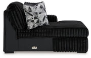 Ashley Furniture Midnight-Madness sectional with chaise, showcasing plush fabric and modern design in a spacious living room setting.