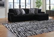 Ashley Furniture Midnight-Madness sectional sofa with chaise, dark fabric upholstery and modern design, shown in a stylish living room setting.