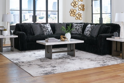 Ashley Furniture Midnight-Madness sectional sofa with dark fabric upholstery and plush cushions, shown in a stylish living room setting.