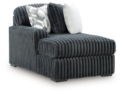 Ashley Furniture Midnight-Madness Super Chaise sectional in dark fabric, showing an angled side view with plush cushions and modern design.