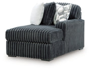 Ashley Furniture Midnight-Madness Super Chaise sectional in dark fabric with plush cushions, viewed from an angled side.