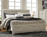 Ashley Furniture Bellaby Bed with a wooden frame and headboard, showcasing a modern design in a cozy bedroom setting.