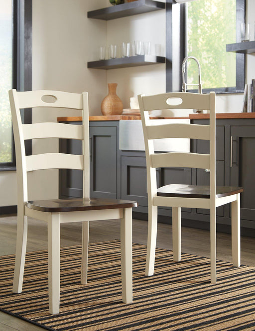 Set of Ashley Furniture Woodanville dining chairs with wooden seats and backrests, arranged around a dining table.