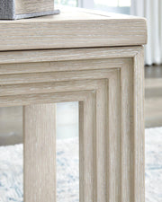 Ashley Furniture Marxhart End Table with wooden top and sleek metal legs, modern design for living room or bedroom.
