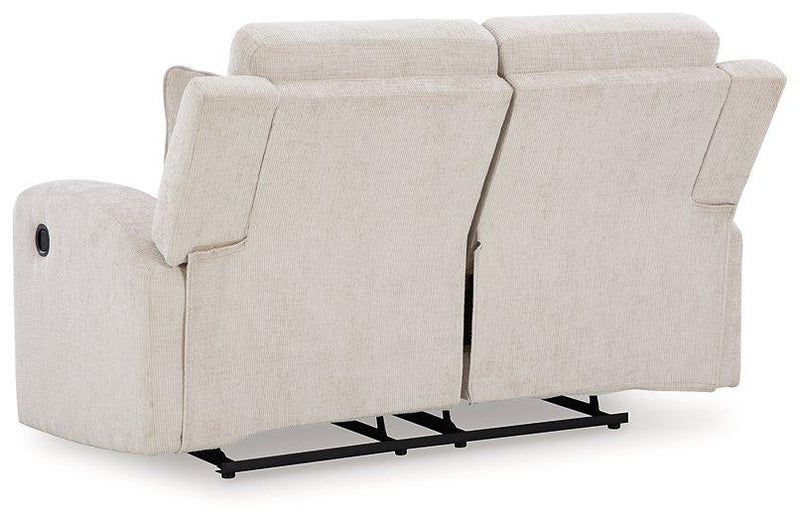 Ashley Furniture Danum reclining loveseat with plush fabric and padded armrests, shown in a cozy living room setting.