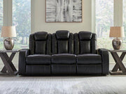 Ashley Furniture Caveman Den power reclining sofa with plush cushions and reclining features, shown in a modern living room setting.