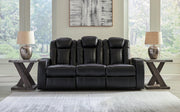 Ashley Furniture Caveman Den Power Reclining Sofa, plush fabric, padded armrests, and reclining features for comfortable seating.