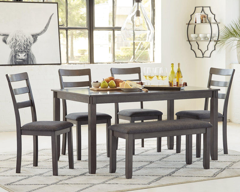Ashley Furniture dining table set with matching chairs and bench, showcasing a modern wooden dining room arrangement.