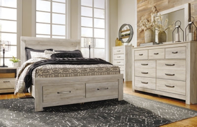Ashley Furniture Bellaby Bed with a modern wooden frame and neutral finish, shown in a cozy bedroom setting.