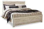 Ashley Furniture Bellaby Bed with a wooden frame and headboard, shown in a cozy bedroom setting.