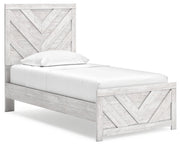 Ashley Furniture Cayboni Bed with elegant wooden frame and angled headboard, shown from a side angle.