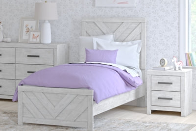 Ashley Furniture Cayboni Bed with woven headboard and wooden frame, shown in a cozy bedroom setting.