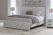 Ashley Furniture Cayboni Bed with wood frame and detailed headboard, shown in a cozy bedroom setting.