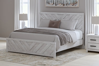 Ashley Furniture Cayboni Bed with wood frame and detailed headboard, shown in a cozy bedroom setting.
