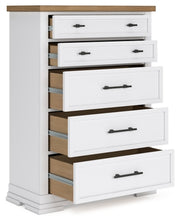 Open angled view of Ashbryn Chest of Drawers by Ashley Furniture showing multiple drawers and wood finish.