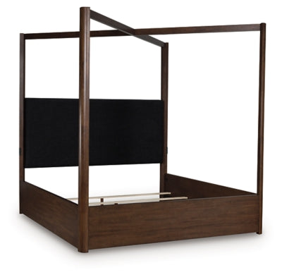 Ashley Furniture Dilenno bed with a wooden frame and neutral upholstery, shown from a side angle.