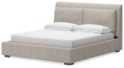 Ashley Furniture Cabalynn upholstered bed with a plush headboard and elegant design, shown from a side angle.