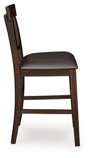 Ashley Furniture Haddigan counter height bar stool with wooden legs and upholstered seat, viewed from the side.