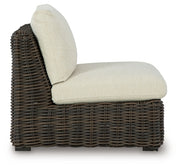 Ashley Furniture Kimora outdoor sectional with beige cushions and dark wicker frame, shown on patio setting.