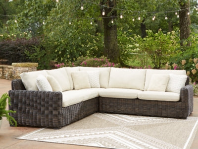 Ashley Furniture Kimora outdoor sectional with plush cushions and woven rattan frame, ideal for patio seating.