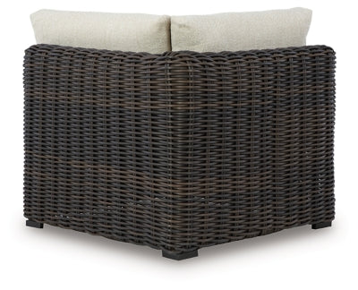 Kimora outdoor sectional by Ashley Furniture with plush cushions and wicker frame, designed for comfortable outdoor seating.