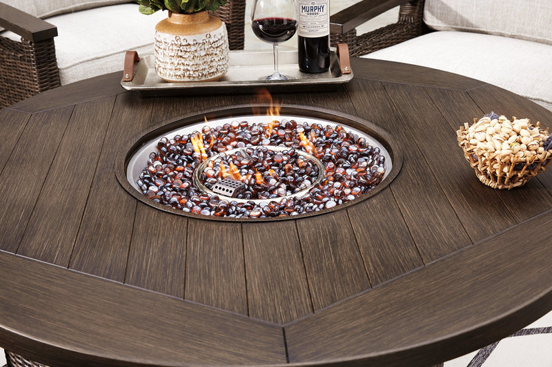 Outdoor seating set featuring a Paradise Trail fire pit table and four Nuvella swivel lounge chairs by Ashley Furniture.