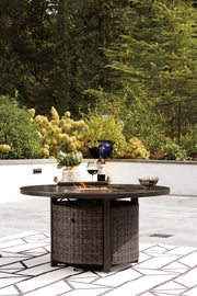 Outdoor seating set featuring a Paradise Trail fire pit table and four Nuvella swivel lounge chairs by Ashley Furniture.