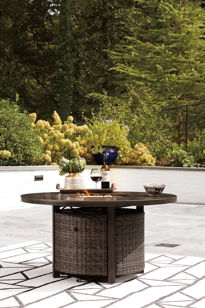 Outdoor seating set featuring a Paradise Trail fire pit table and four Nuvella swivel lounge chairs by Ashley Furniture.