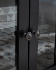 Close-up of the knob detail on the Wildenauer 76-inch TV stand by Ashley Furniture in natural wood finish
