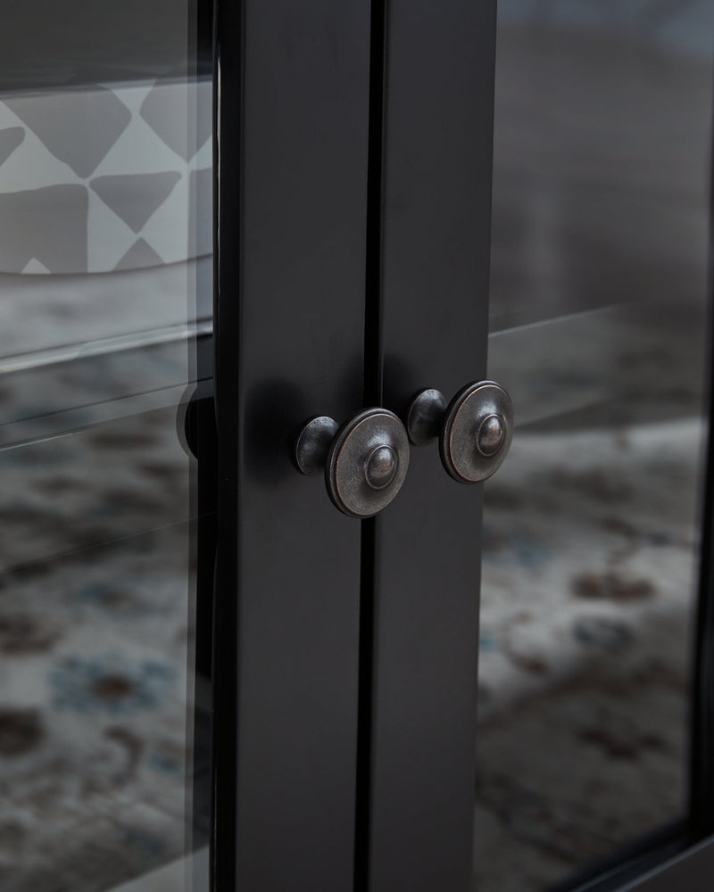 Close-up of the knob detail on the Wildenauer 76-inch TV stand by Ashley Furniture in natural wood finish